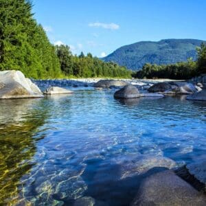 A river with rocks in it and trees around.
